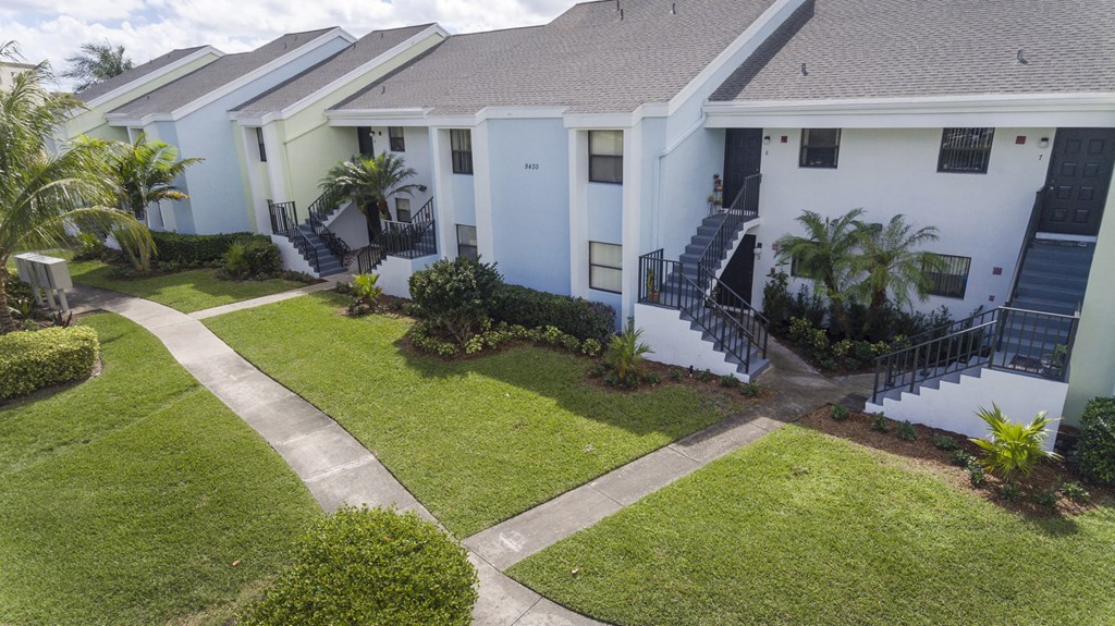 A white building with a green lawn in front.